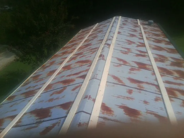 Rusted metal roof panels with new wood purlins before replacement — Storm Damage Roof Repair in Teachey by Roofing Brothers