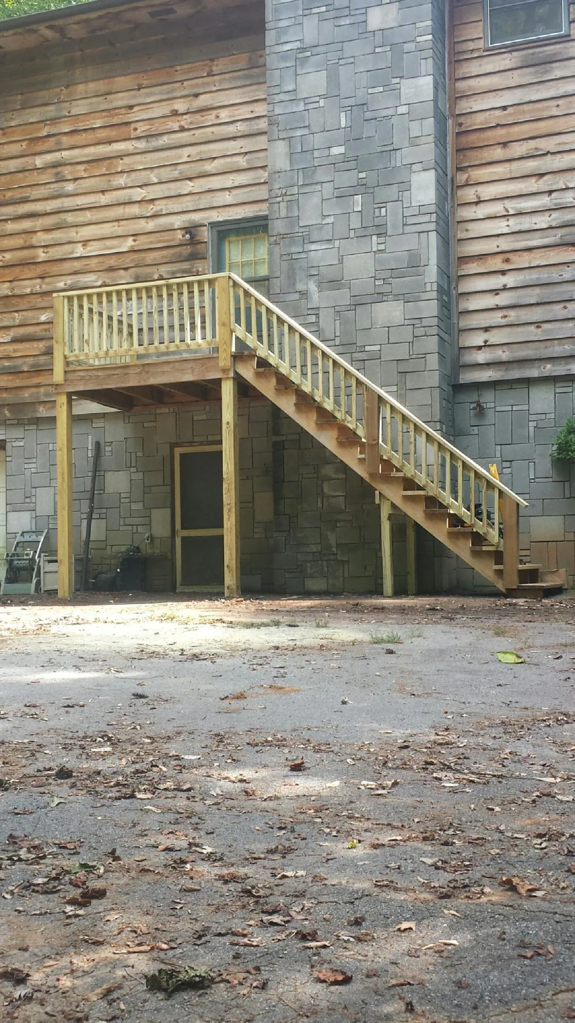 New pressure treated deck and stair landing on a log home in Teachey