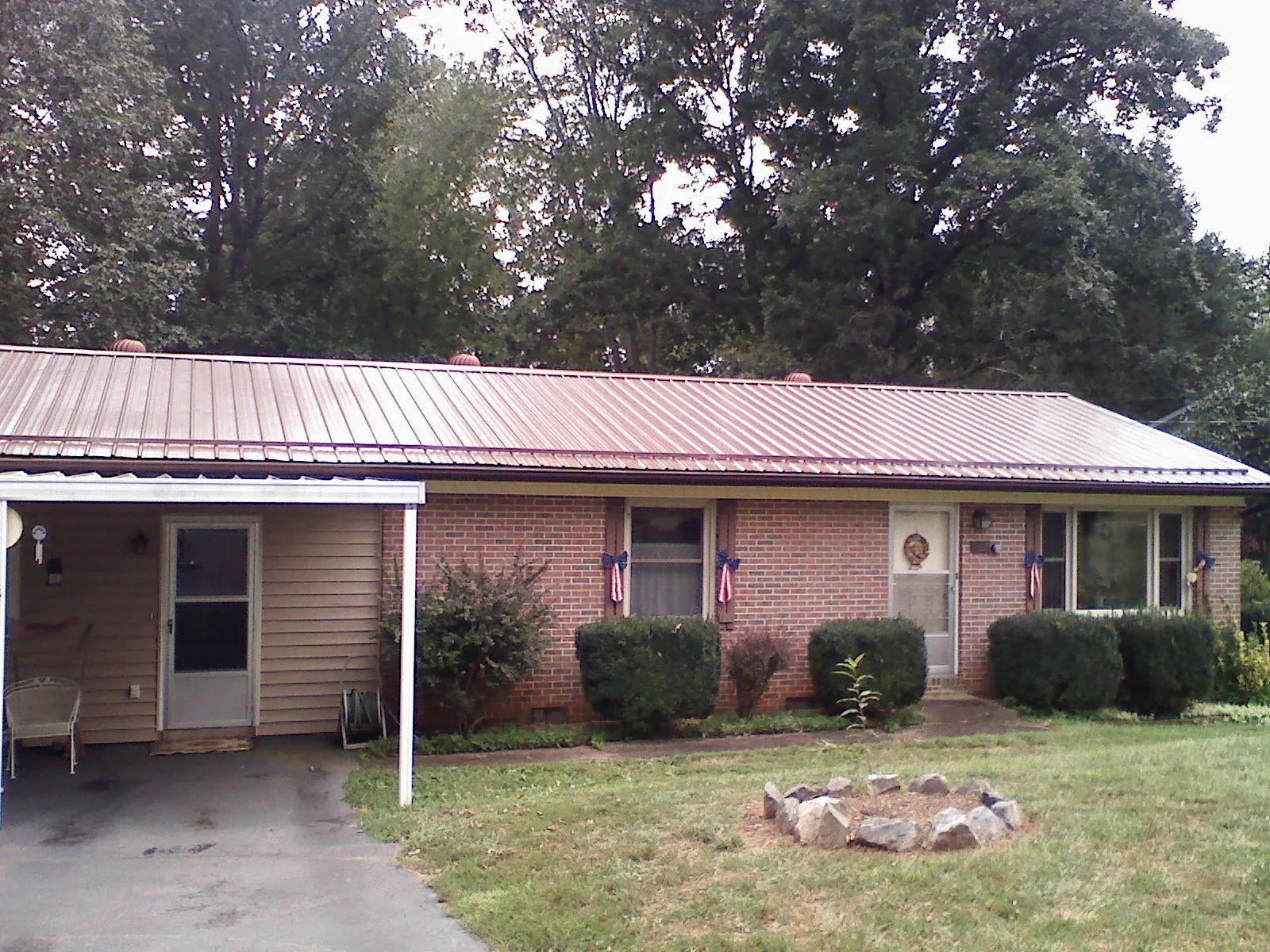 Bronze metal roof and carport on a brick ranch home — Roof Repair work by our crew in Teachey
