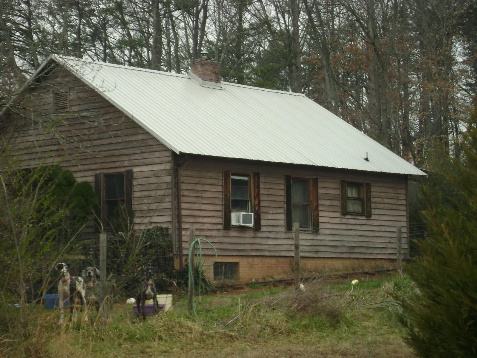 White metal roof on an old wood sided farmhouse, from a Metal Roof Installation job in Teachey